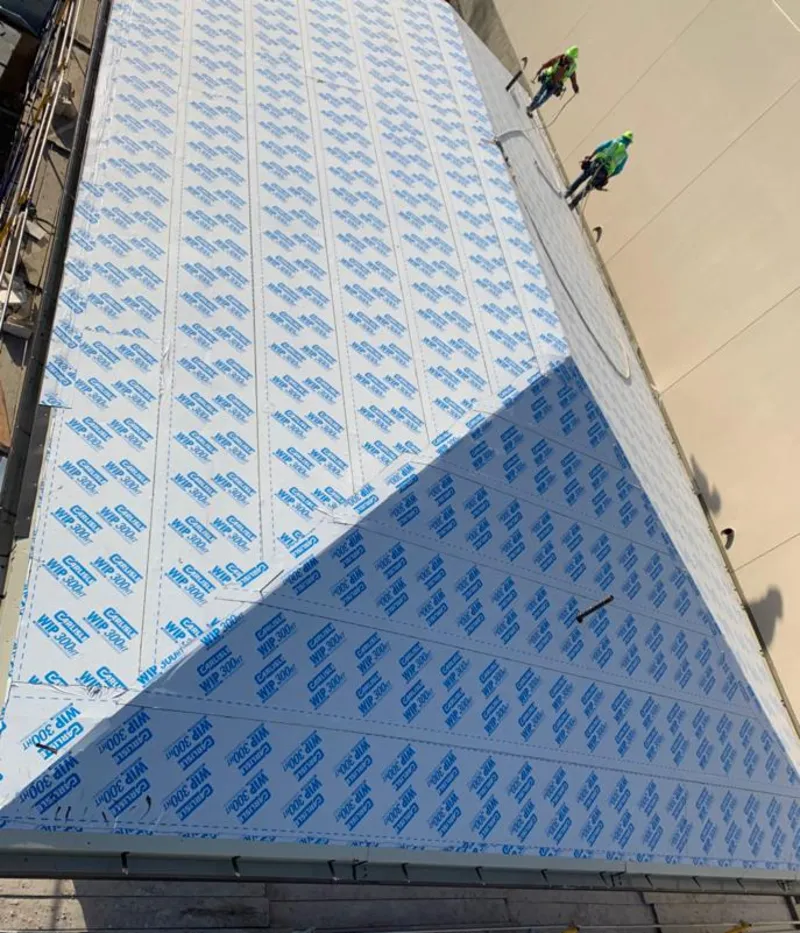 Professional roofers installing underlayment on a metal roof in Barbecue